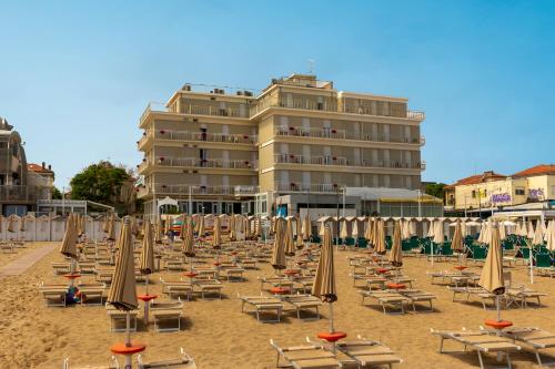a bunch of chairs and umbrellas on a beach at Hotel President's in Pesaro