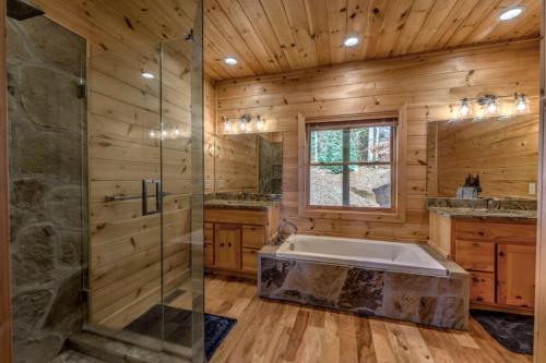 a bathroom with a tub and a glass shower at Rudy's Retreat in Ellijay
