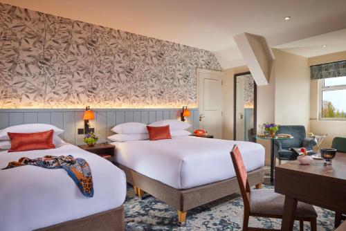 um quarto de hotel com duas camas e uma escrivaninha em Hodson Bay Hotel em Athlone