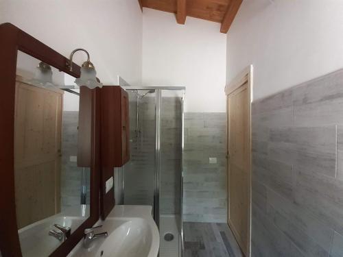 La salle de bains est pourvue d'une douche en verre et d'un lavabo. dans l'établissement Agriturismo D'Apostolo, à Amatrice