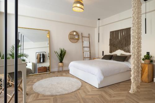 a bedroom with a white bed and a mirror at K-Houses A1 in Arta