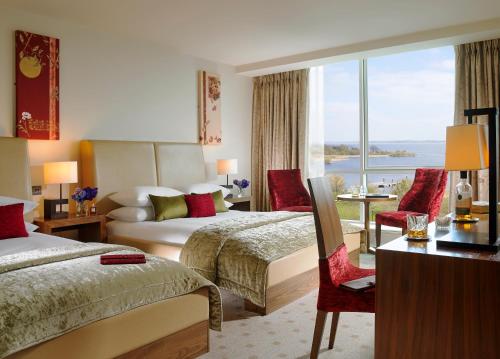ein Hotelzimmer mit 2 Betten und einem großen Fenster in der Unterkunft Hodson Bay Hotel in Athlone