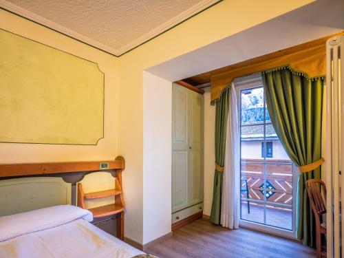 Una cama o camas en una habitación de Albergo Dimaro Wellness Hotel
