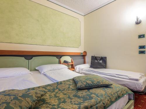 Una cama o camas en una habitación de Albergo Dimaro Wellness Hotel