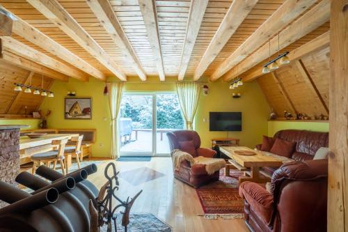 a living room with leather furniture and a wooden ceiling at Villa Teodora in Kopaonik