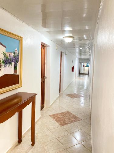a hallway with white walls and a painting on the wall at LUTIX HOTELS in El Limón