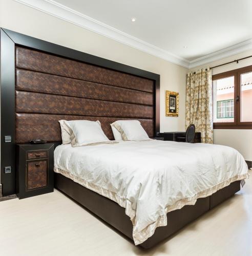 a bedroom with a large bed with a large headboard at Rok Plaza in Alcalá