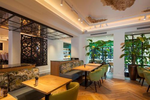 a restaurant with wooden tables and green chairs at Boutique Hotel Jersey in Goes