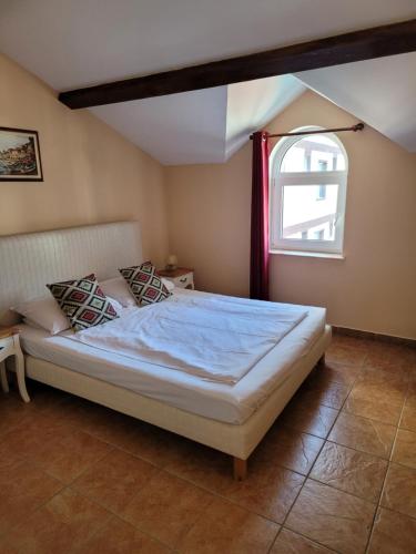 a bedroom with a bed and an open window at Villa Favorita in Eforie Sud