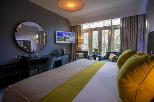 a hotel room with a large bed and a mirror at Fota Island Hotel and Spa in Fota Island