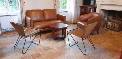 un salon avec un canapé, des chaises et une table dans l'établissement Le Clos de La Rousseliere, à Francueil