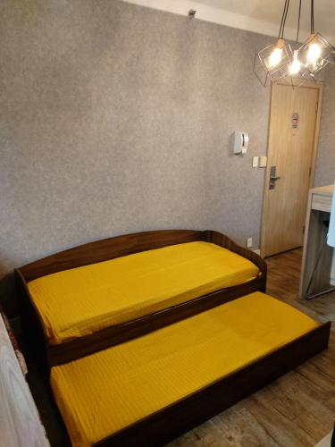 two beds in a room with yellow sheets at Airport Business Flat Guarulhos - São Paulo in Guarulhos