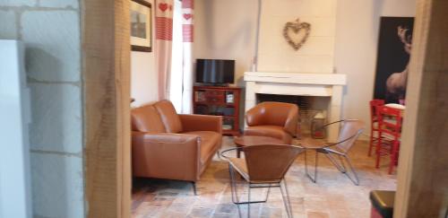 ein Wohnzimmer mit Stühlen, einem Tisch und einem Kamin in der Unterkunft Le Clos de La Rousseliere in Francueil