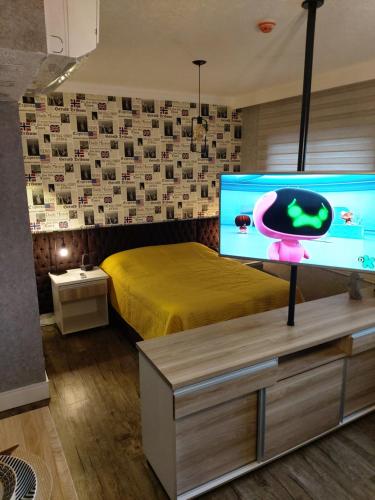 a bedroom with a bed and a large screen tv at Airport Business Flat Guarulhos - São Paulo in Guarulhos