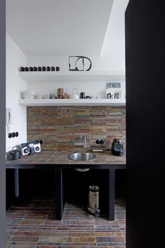 a kitchen with a sink and a brick wall at Mini Loft ULB DELTA area with terrace in Brussels
