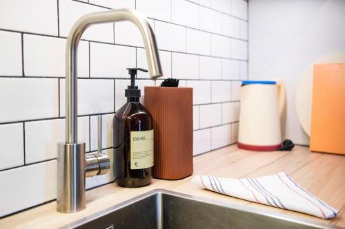 uma garrafa de vinho sentada ao lado de um lavatório de cozinha em The Beach apartments by Daniel&Jacob's em Copenhaga