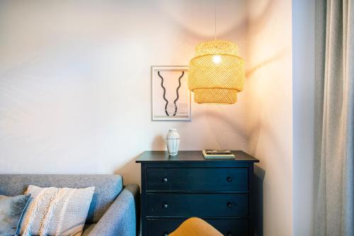 a bedroom with a blue dresser and a lamp at The Beach apartments by Daniel&Jacob's in Copenhagen