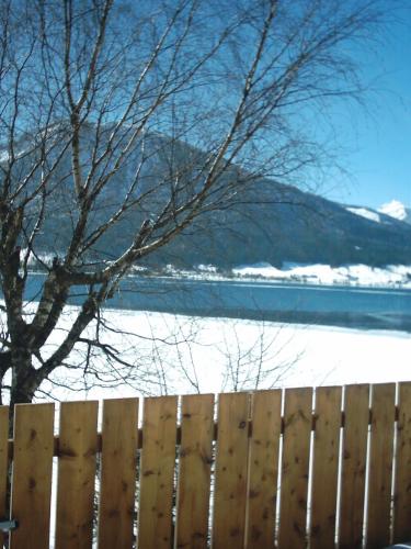 a wooden fence next to a snow covered field at Apartmenthaus WALDHORN in St. Wolfgang