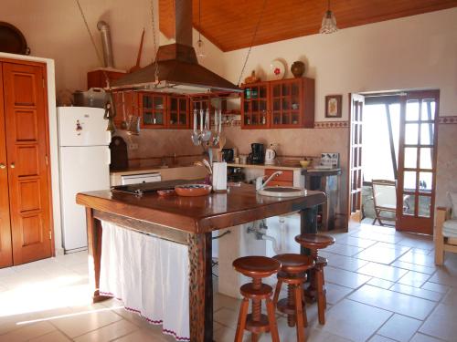 a kitchen with a large wooden island with stools at Pines of Salgado beachview villa by Book YourHoliday PT in Nazaré