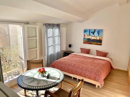 une chambre avec un lit, une table et une fenêtre dans l'établissement Art Apparts coeur de ville, à Béziers