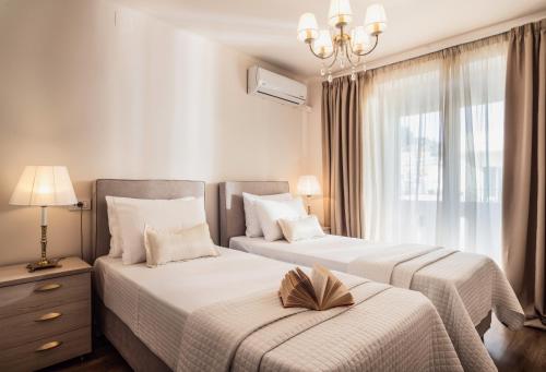 a bedroom with two beds and a window at Maison Downtown Luxury Apartments! in Zakynthos Town