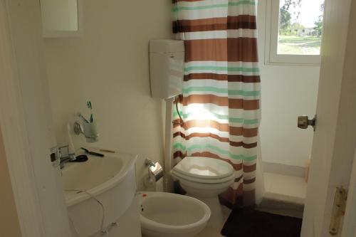 Un baño con inodoro y cortina de ducha. en Rincon del Diario, en Punta del Este
