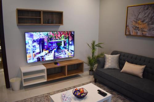 un soggiorno con TV a schermo piatto a parete di مساكن كيو a Dammam