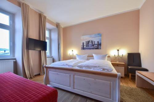 ein Schlafzimmer mit einem weißen Bett mit einer roten Decke in der Unterkunft Villa Magdalena 05 in Ahlbeck