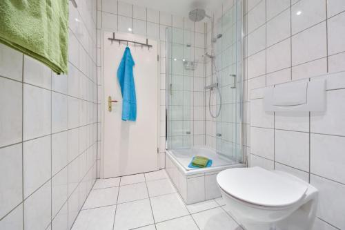 a white bathroom with a toilet and a shower at Villa Magdalena 05 in Ahlbeck
