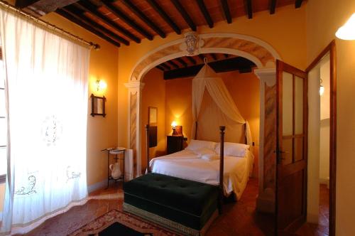 Palazzo Bizzarri في رابولانو تيرمي: غرفة نوم بسرير في غرفة بها قوس