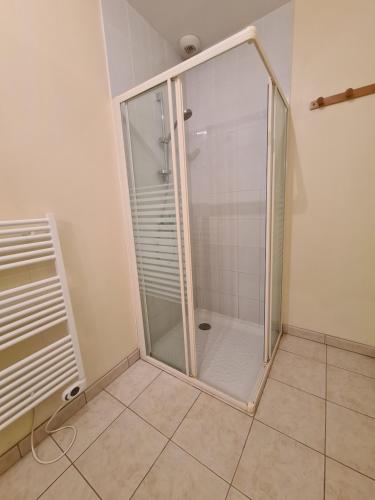 a glass shower in a bathroom with a tiled floor at Gîte le Vallon à Chambretaud, 5 min du Puy du Fou in Chambretaud