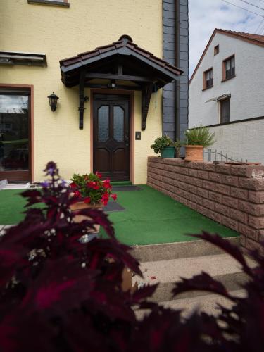 a house with a door and a green lawn at Ferienwohnung Maxima in Weiskirchen