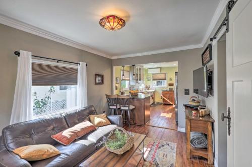 a living room with a leather couch and a kitchen at Charming Craftsman Bungalow with Garden and Hot Tub! in Fullerton