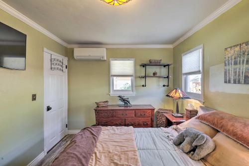 a bedroom with a bed and a desk and windows at Charming Craftsman Bungalow with Garden and Hot Tub! in Fullerton