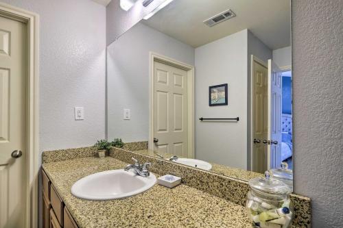 a bathroom with a sink and a large mirror at Walk to Grand Lake Modern Afton Townhome! in Afton