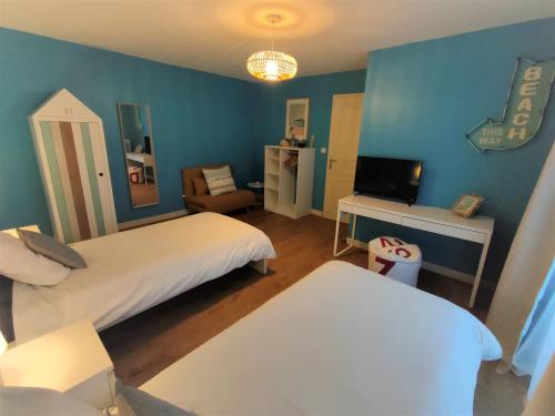 a hotel room with two beds and a television at Maison de pêcheur Port de plaisance Tréboul in Douarnenez