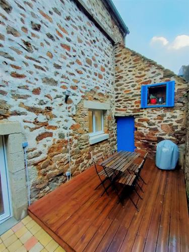 a wooden deck with a bench and a building at Maison de pêcheur Port de plaisance Tréboul in Douarnenez