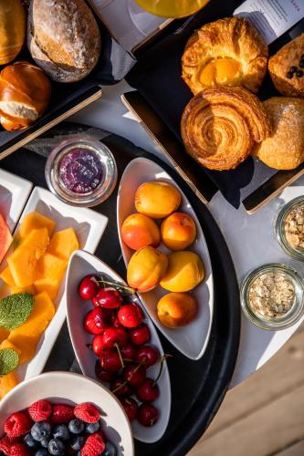 a table with a bunch of different types of bread and fruit at Hotel Aurora in Merano