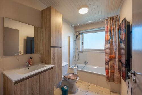 een badkamer met een wastafel, een toilet en een bad bij Westende Marinapark Bungalow Blue in Middelkerke