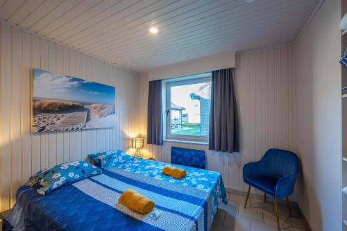 ein Schlafzimmer mit einem blauen Bett und einem Fenster in der Unterkunft Westende Marinapark Bungalow Blue in Middelkerke