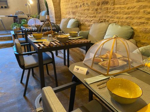 - une salle avec des canapés et des tables avec des bols dans l'établissement La maison des couturières, à Cluny