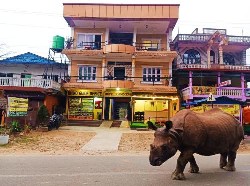 a bull walking down a street in front of a building at Hotel Rhinoceros-Homestay in Sauraha