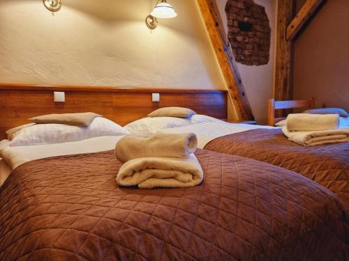 a bedroom with two beds with towels on the bed at Hotel Zamkowy Młyn in Krapkowice