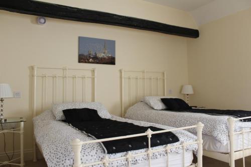 um quarto com duas camas e uma foto na parede em The Bulls Head em Chichester