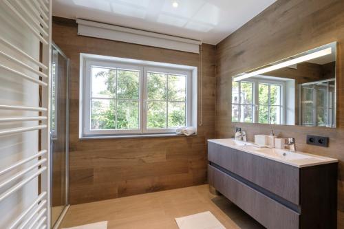 uma casa de banho com um lavatório e um espelho em Apartments in the countryside near Brussels em Lasne