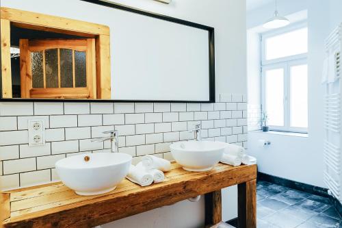 two sinks on a wooden counter in a bathroom at Hostel Multitude in Leipzig