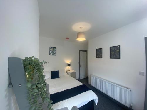 Newhall的住宿－Silver Stag Properties, 4 BR Property，一间卧室,配有床和绿色植物