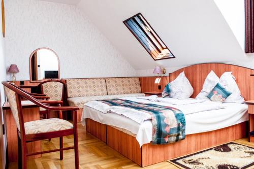 Beatrix Hotel في بودابست: غرفة نوم بسرير ومكتب وكرسي