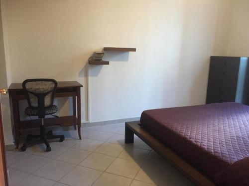 博薩的住宿－Sweet Maison，一间卧室配有一张床、一张桌子和一把椅子