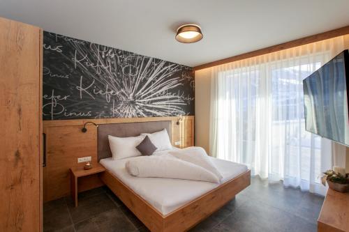 a bedroom with a bed with a chalkboard on the wall at Apart Lutz in Prutz